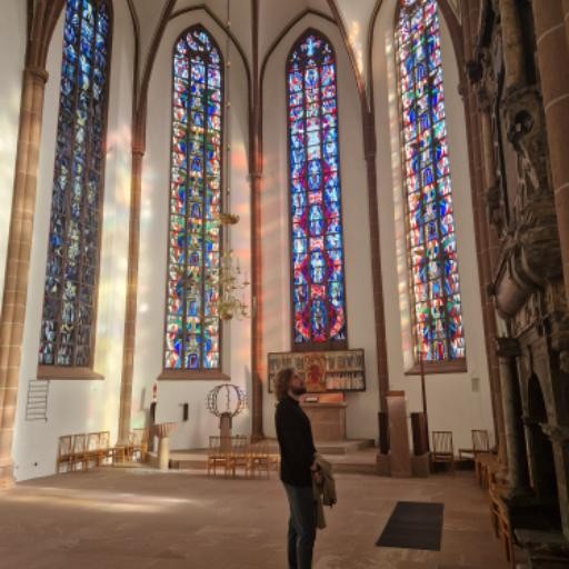 Mann steht im Licht der Kirchenfenster: meditative Haltung, innere Ruhe, inneres Licht und Achtsamkeit im Fokus
